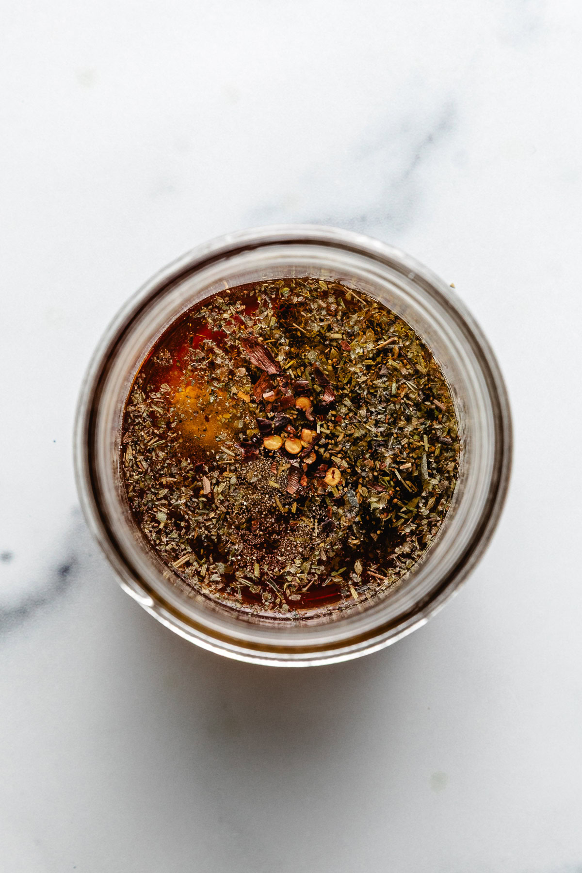 Spices added to a jar from oil and vinegar.