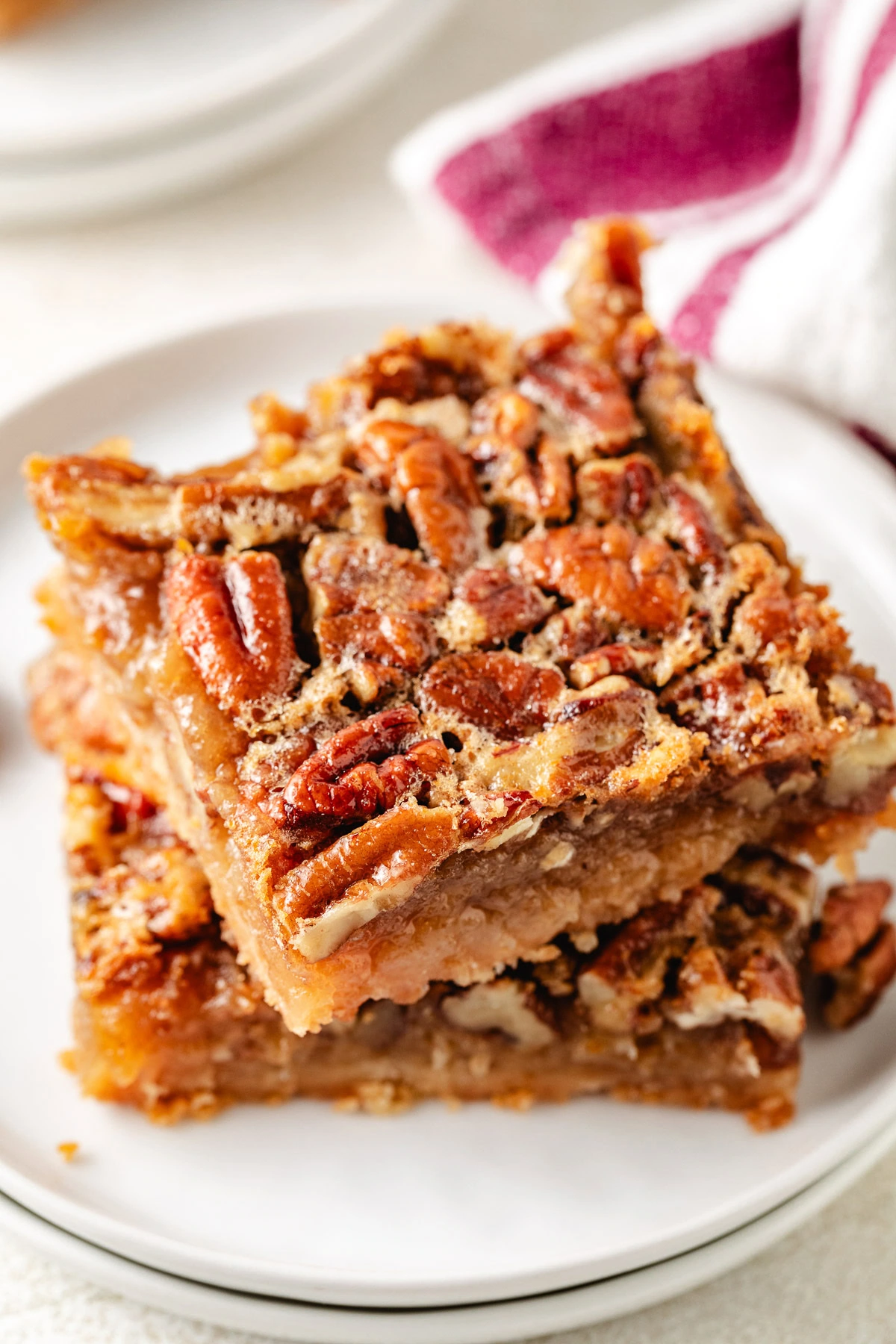 Stack of pecan pie bars on a plate.
