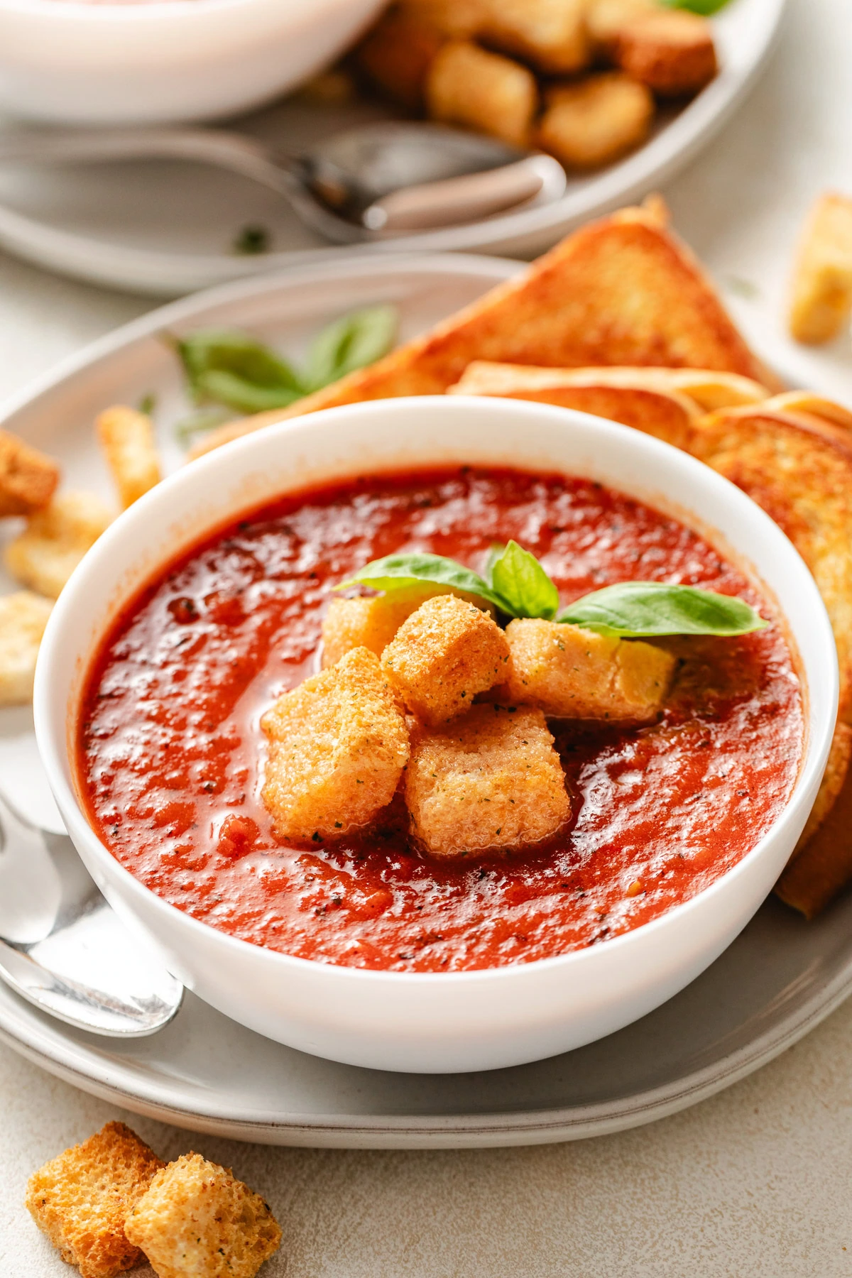 Soup with croutons and basil on top.