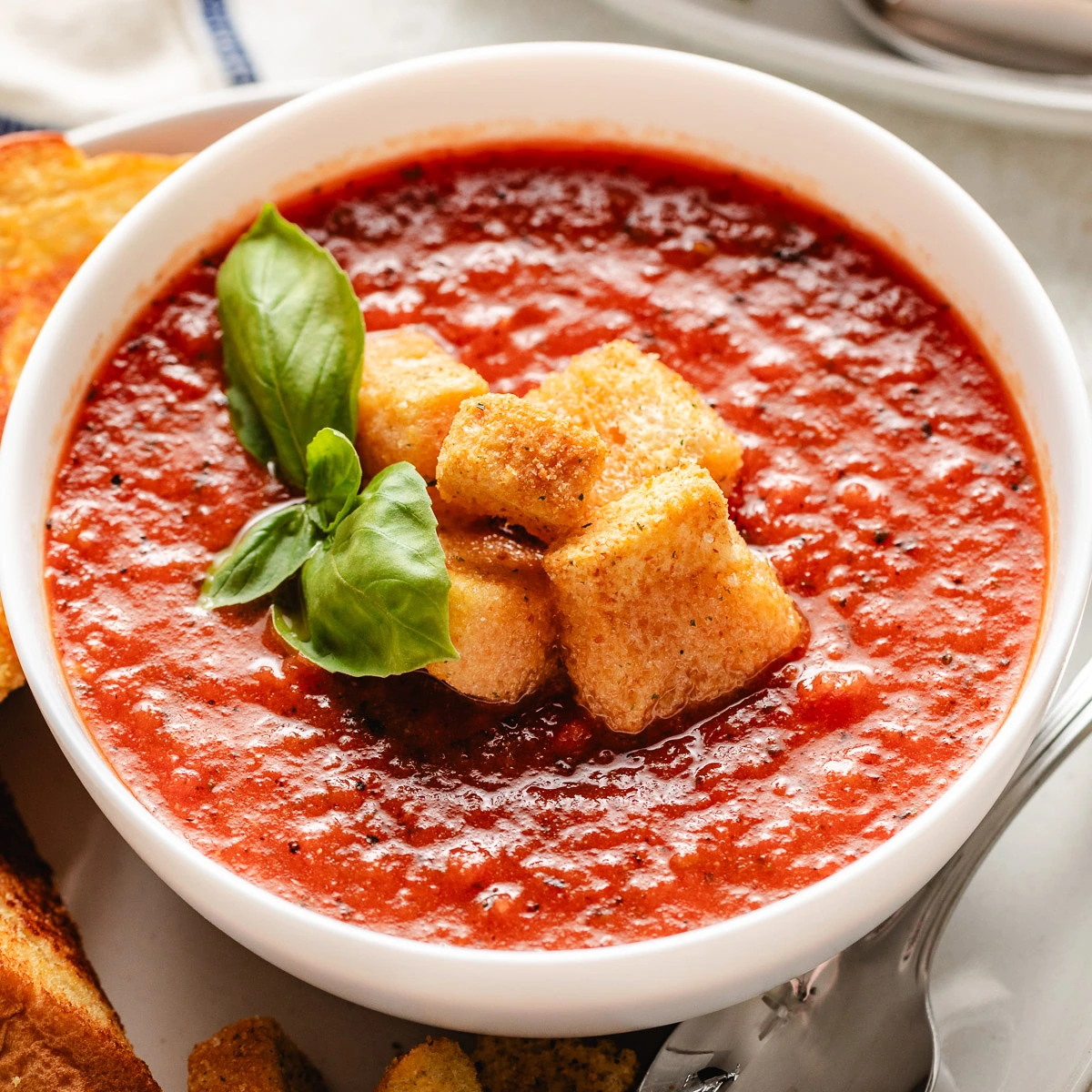 Close up view fo tomato basil soup in a bowl.