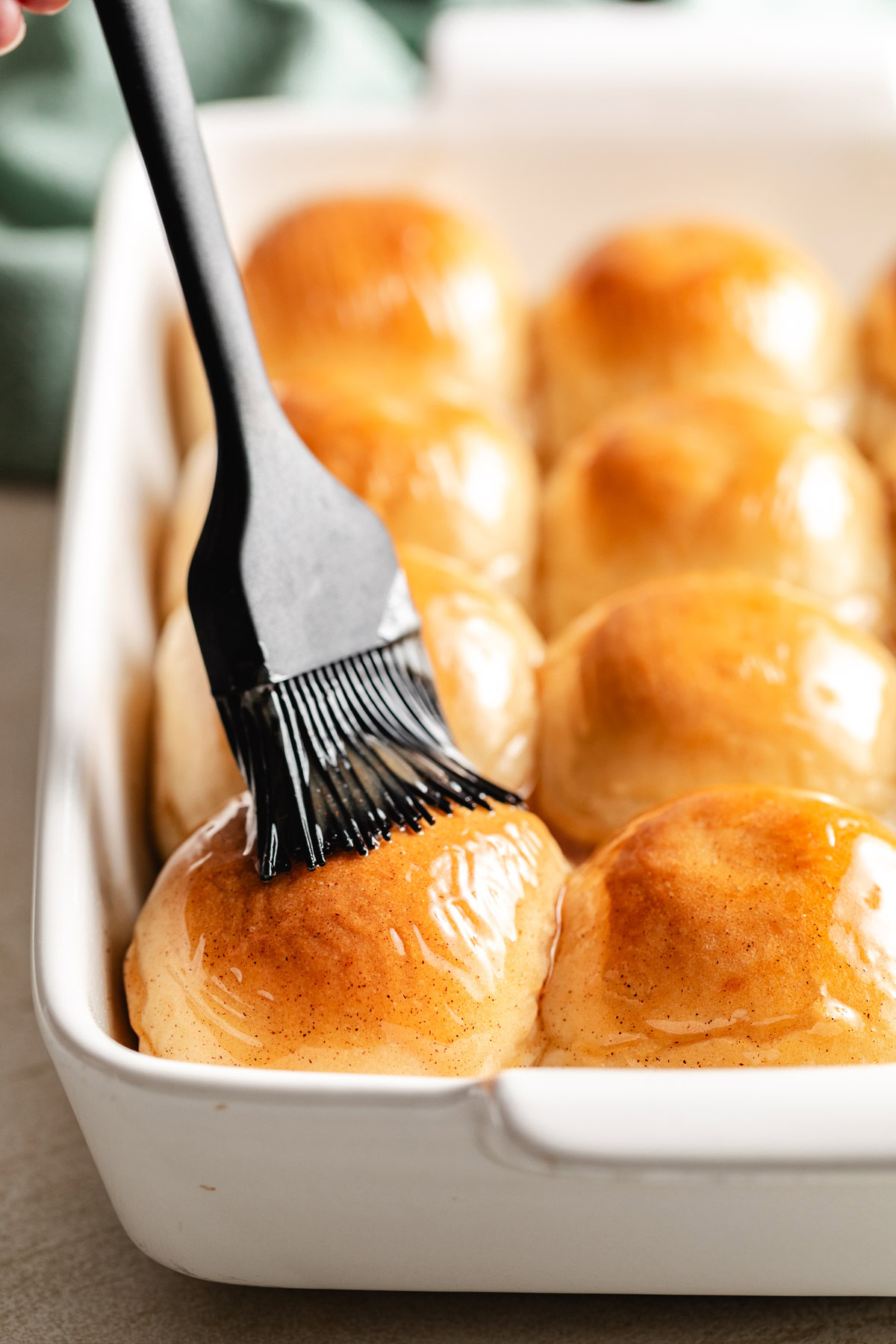 Honey butter glaze being applied to rolls.