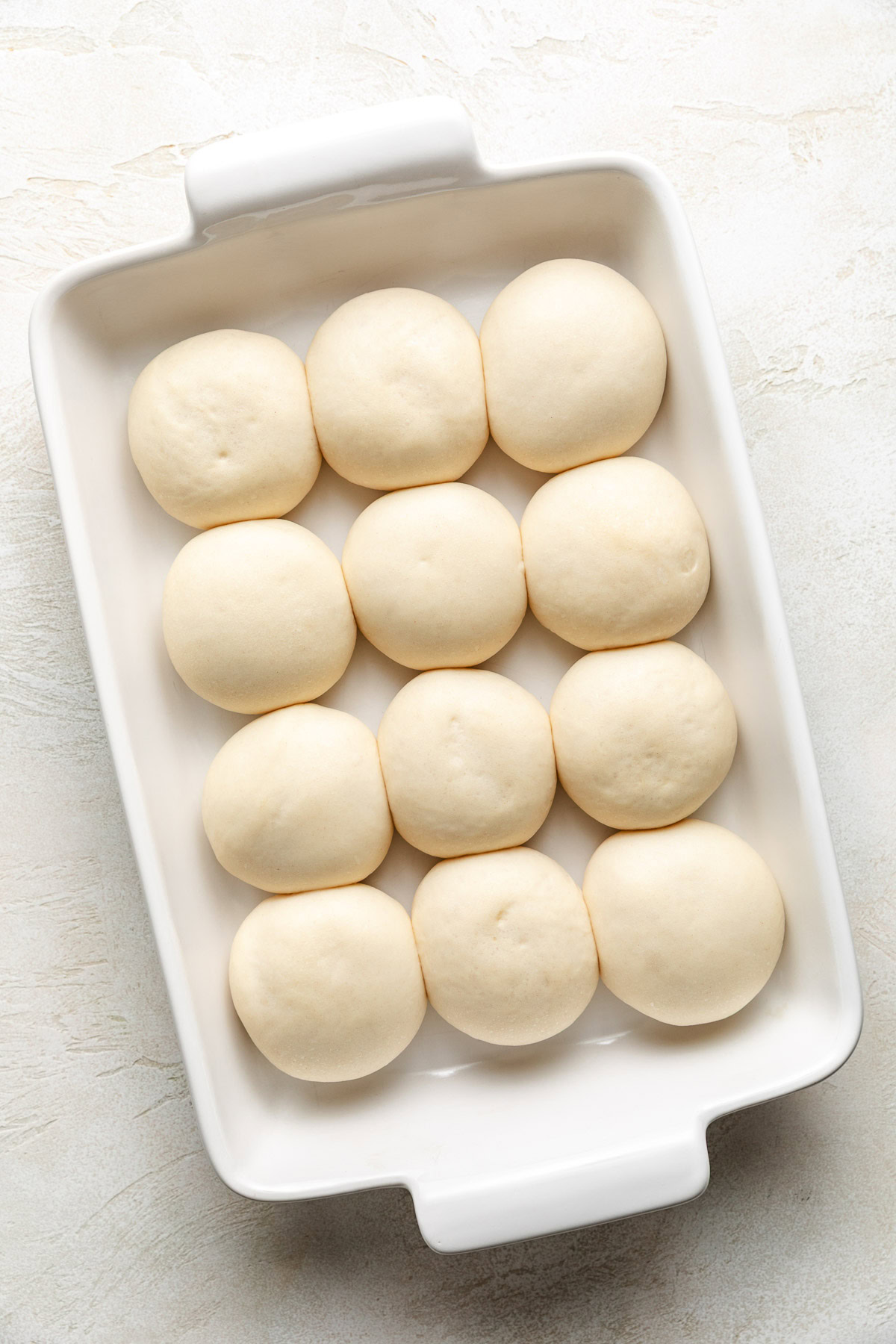 Unbaked rolls in a pan.