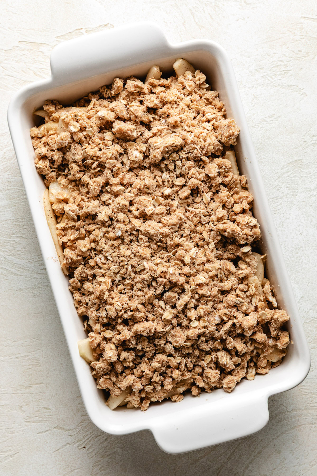 Unbaked pear crisp in a pan.