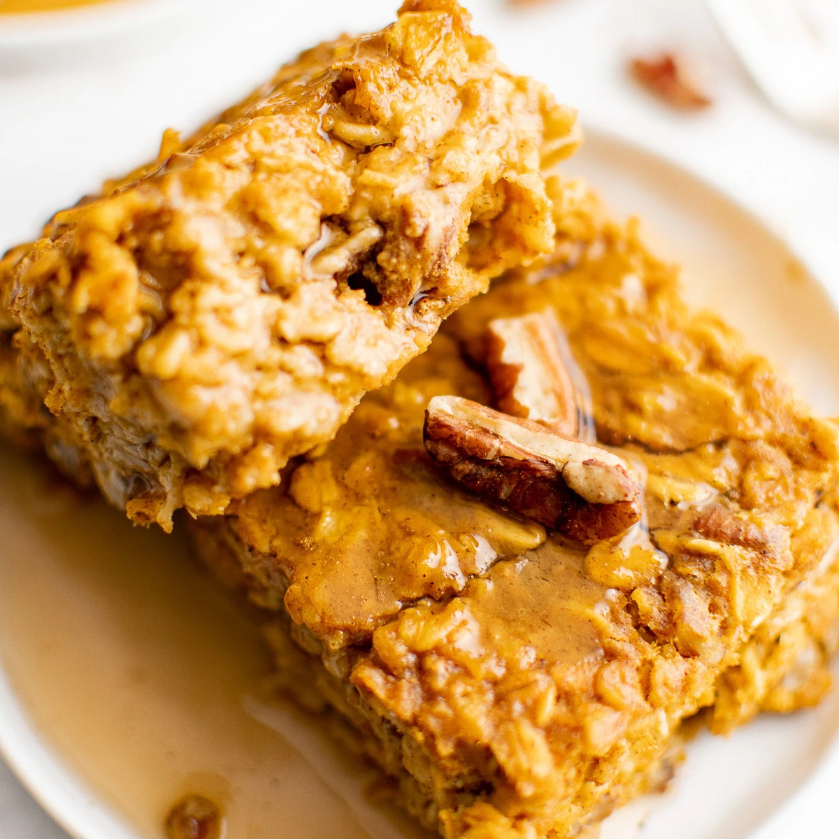 Close up view of syrup and pecans on pumpkin baked oatmeal.