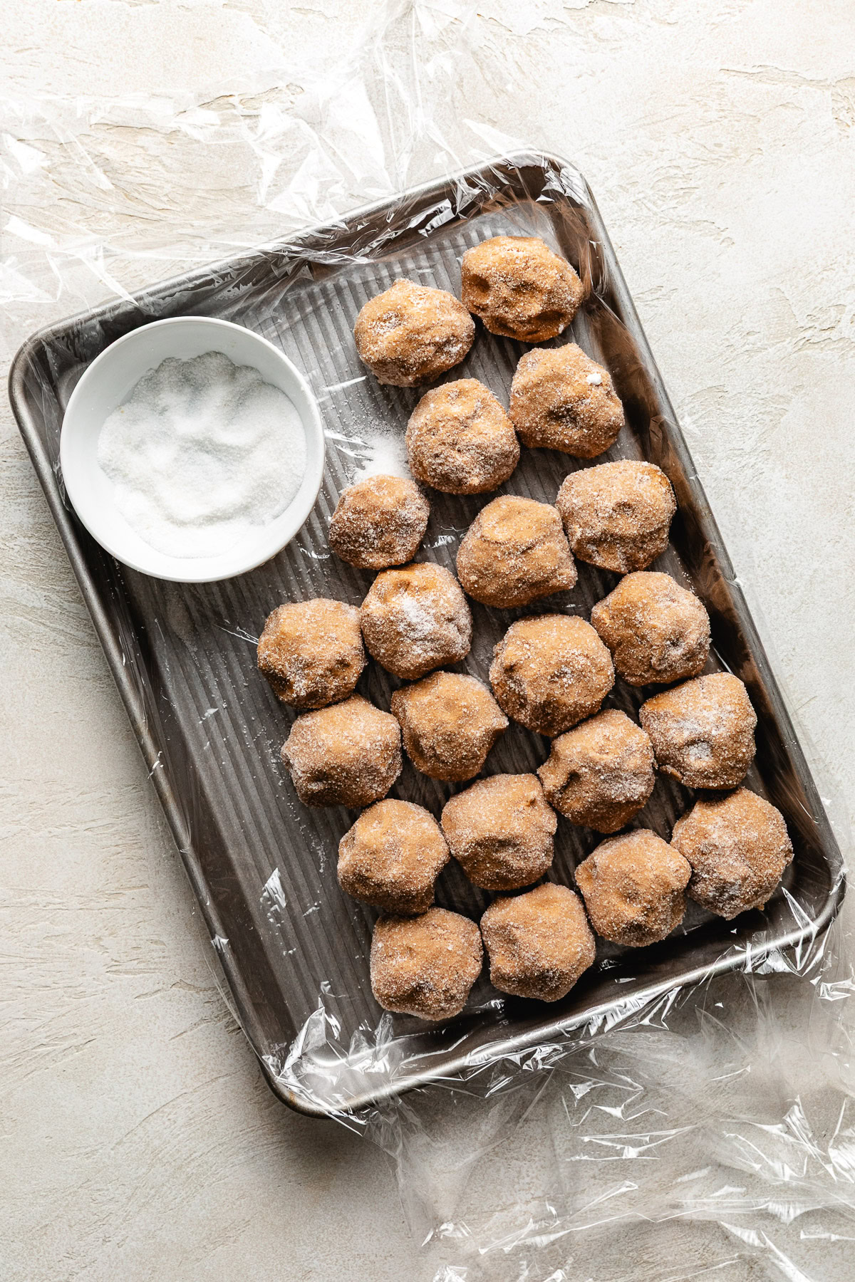 Soft And Chewy Ginger Cookies Tray of unbaked ginger cookie dough and sugar.