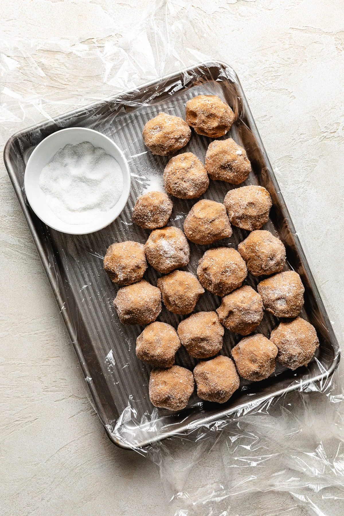 Tray of unbaked ginger cookie dough and sugar.