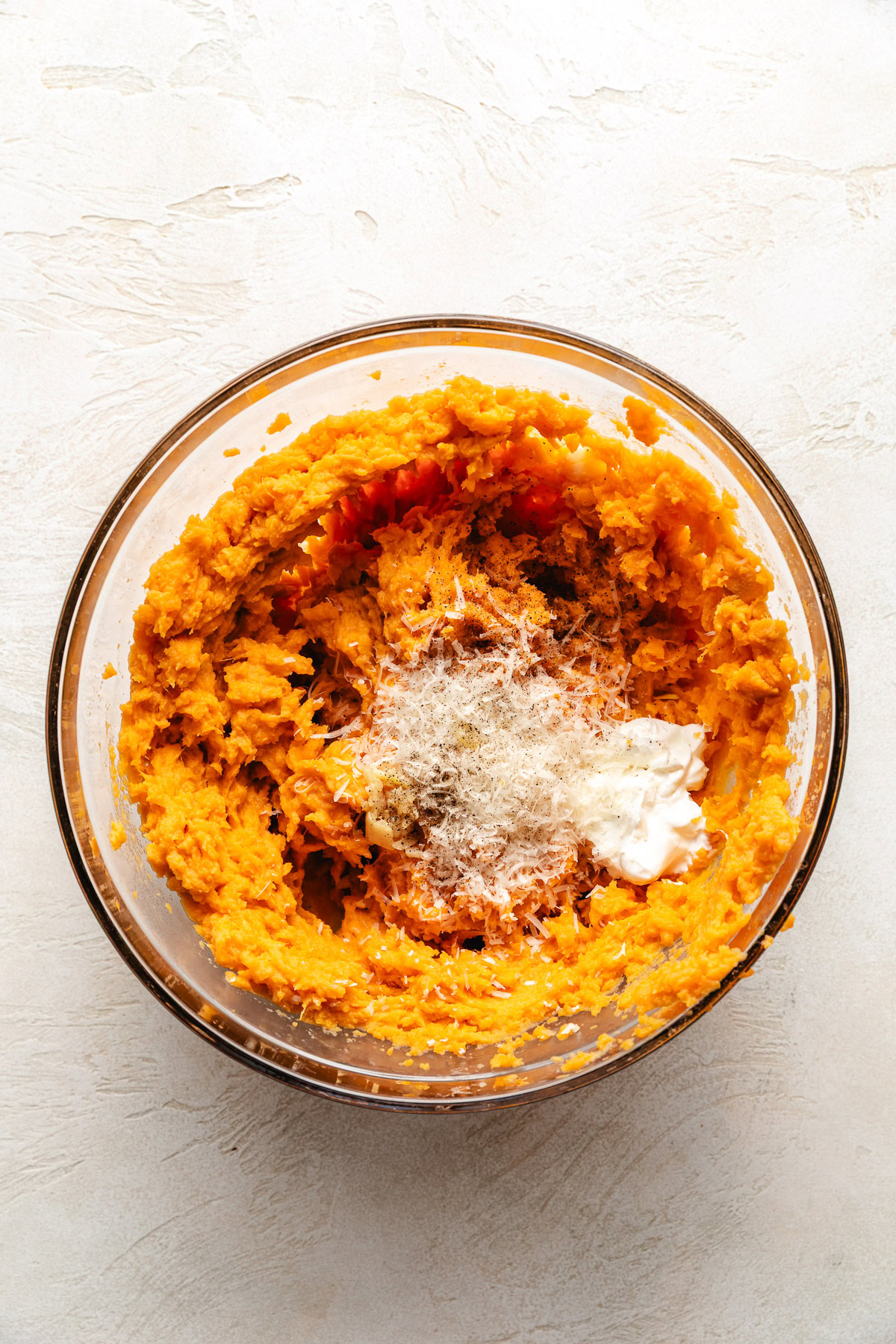 Mixing bowl with potatoes, cheese, sour cream, and butter.