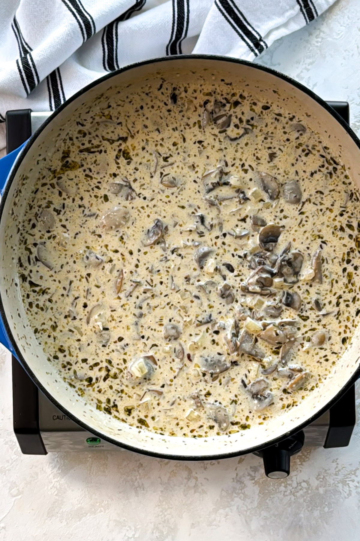 Mushroom shrimp pasta cream sauce after stirring, with mushrooms suspended throughout..