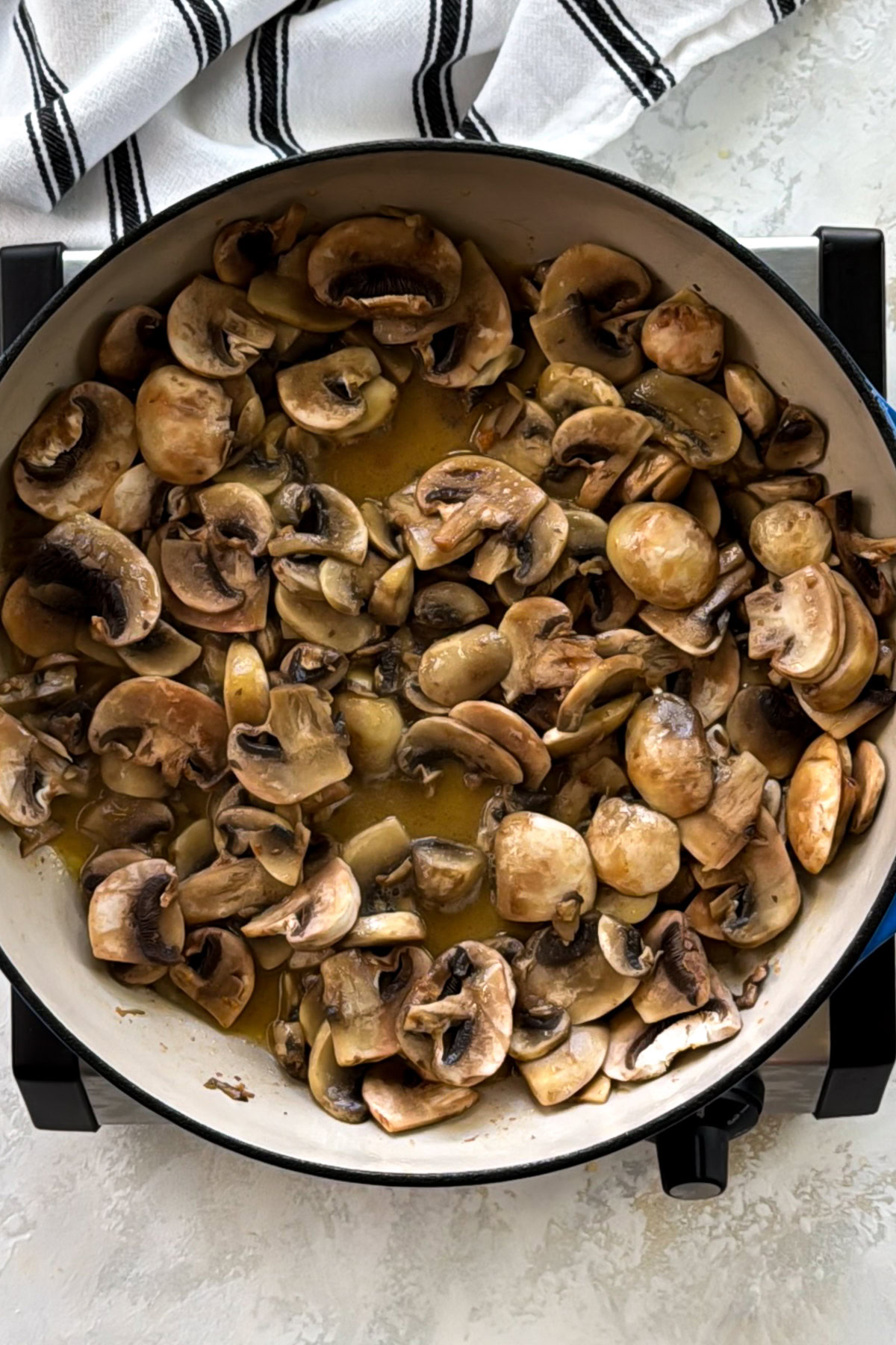 Sautéed mushrooms in a skillet with butter.