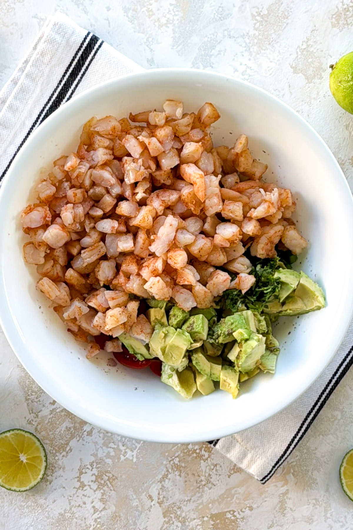 Chopped cooked shrimp and diced avocado in a bowl.