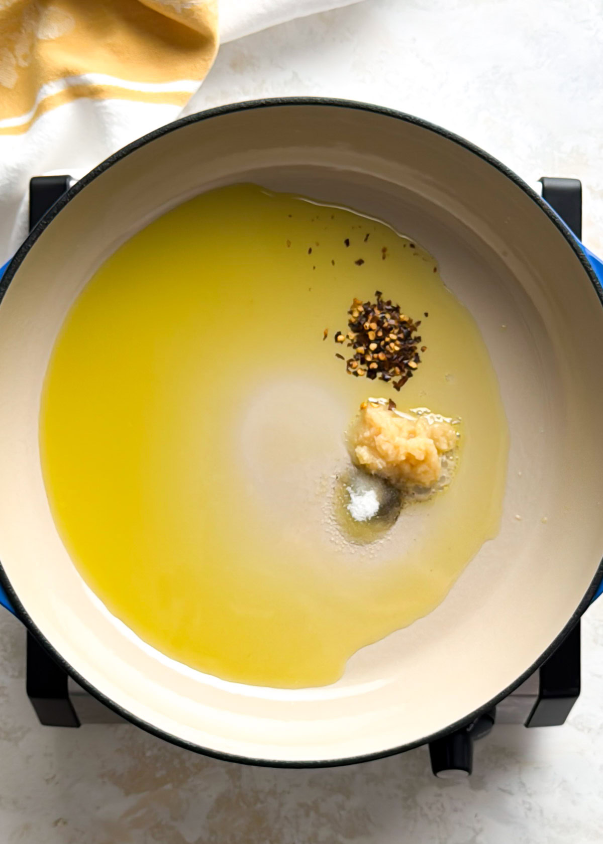 Overhead shot of pasta with tuna and olives on a light countertop.