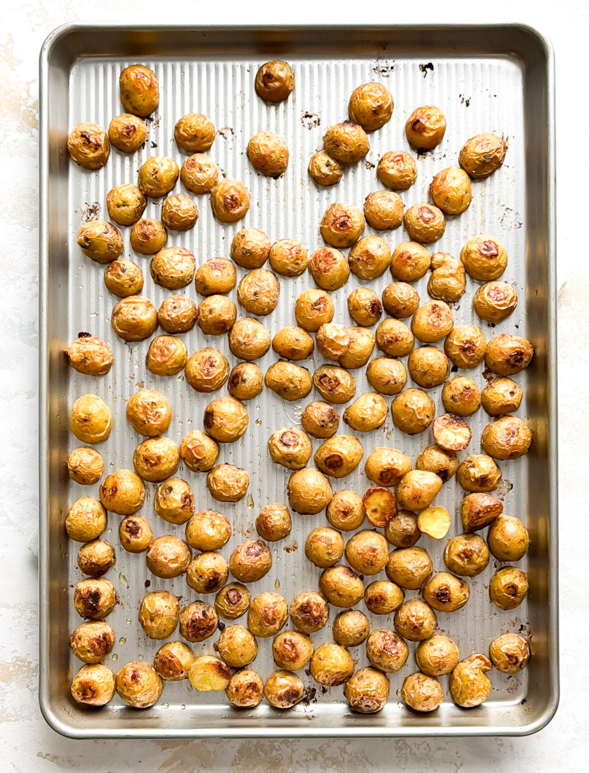 Dill potatoes roasting on a sheet pan.