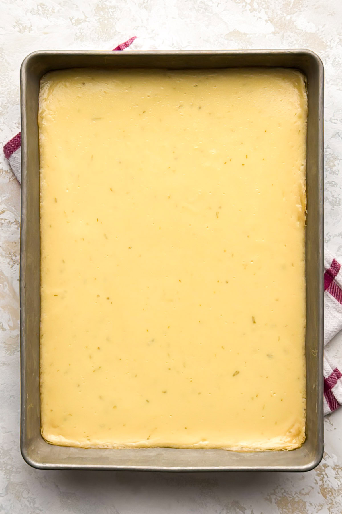 Baked key lime pie bars cooling in a 9x13-inch pan.