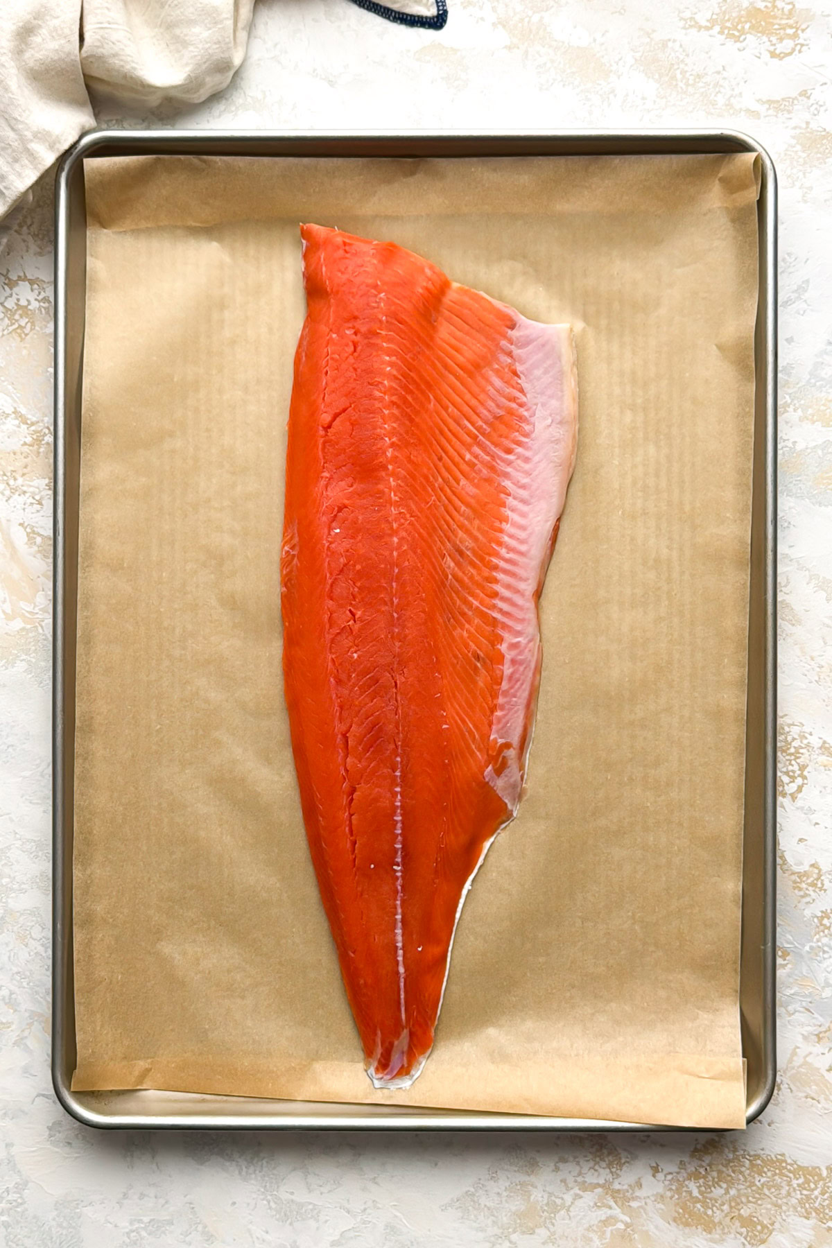 Unbaked salmon fillet on parchment.