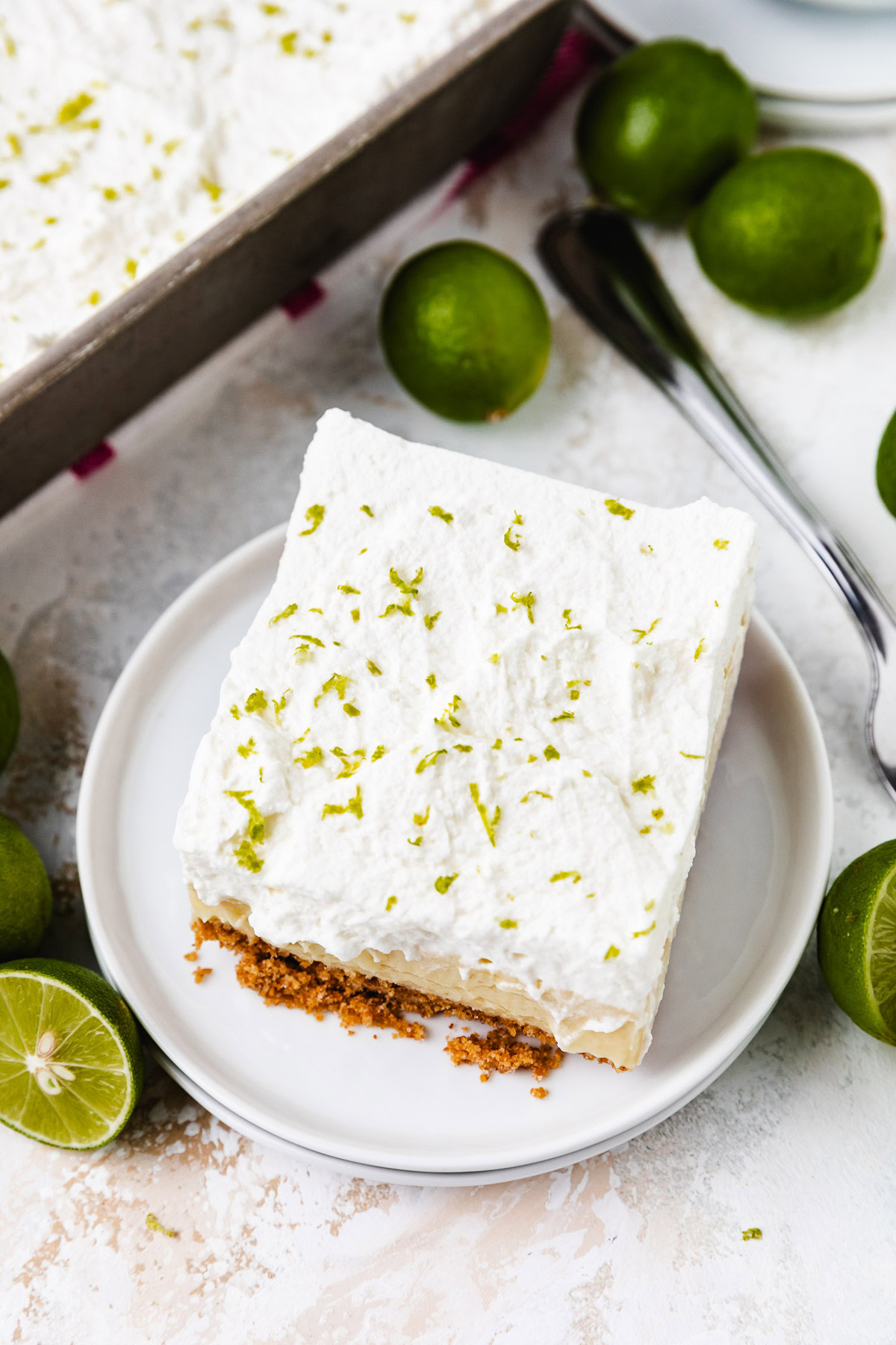 A creamy slice of key lime pie bars topped with whipped cream.