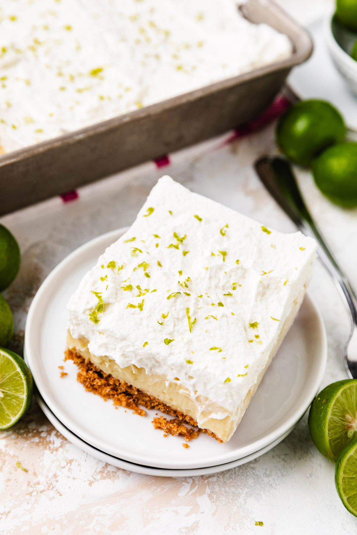 A thick bar topped with whipped cream and lime zest on a white plate.