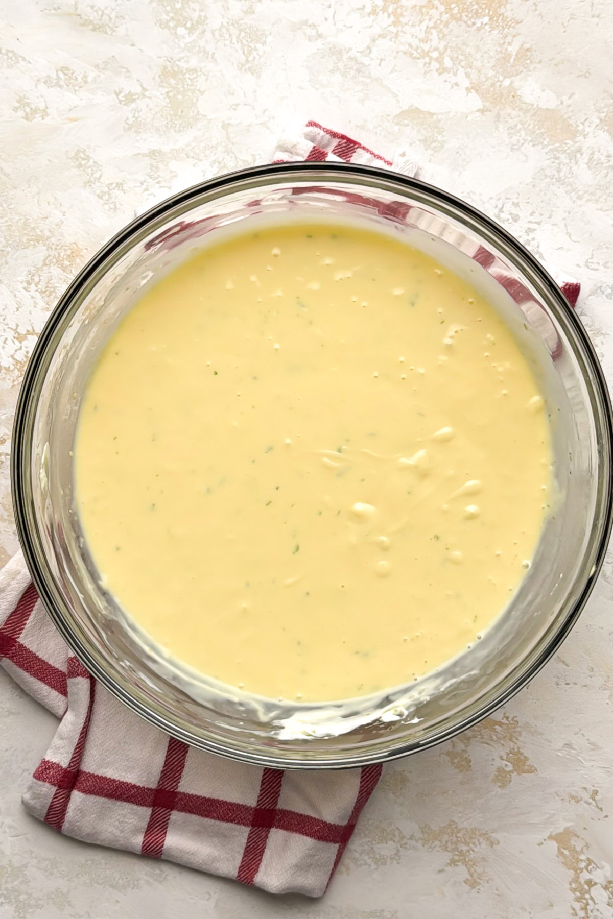 Smooth filling for key lime pie bars in a glass mixing bowl.